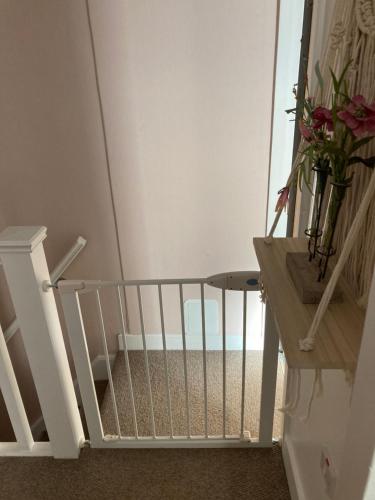 a staircase with a white railing and a vase of flowers at The Wild Daisy in Barnoldswick