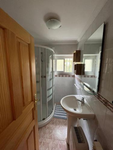 a bathroom with a sink and a shower and a mirror at Casa Mildi Poo Llanes in Po