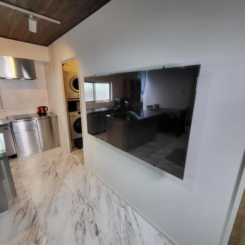a kitchen with a large mirror on the wall at 3ベッド3バス ヴィラアパラギ宮古島 in Miyako Island