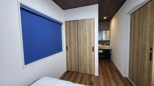 a bedroom with a large window and a door at 3ベッド3バス ヴィラアパラギ宮古島 in Miyako Island