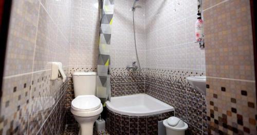 a small bathroom with a toilet and a sink at Habibi Bukhara in Bukhara