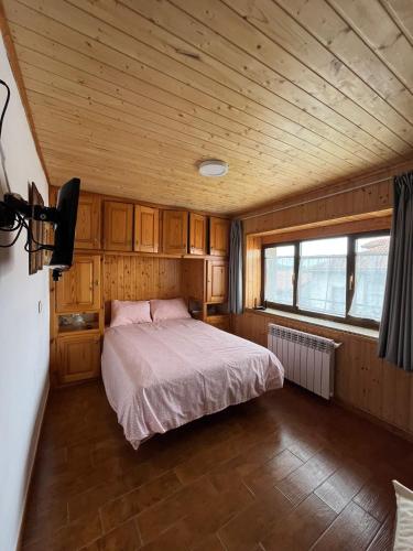 ein Schlafzimmer mit einem Bett in einem Holzzimmer in der Unterkunft Casa Mildi Poo Llanes in Poo de Llanes