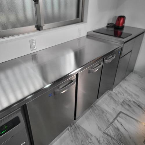 a kitchen with a stainless steel counter top at 3ベッド3バス ヴィラアパラギ宮古島 in Miyako Island