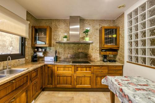 una cocina con armarios de madera y fregadero en Casa rural Mas Plantalech, en Vall de Bianya