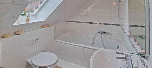 a white bathroom with a toilet and a sink at Appartement Sahi 2 in Celle
