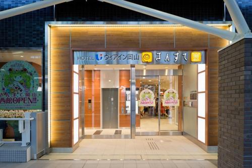 uma entrada para um centro comercial à noite em Via Inn Okayama em Okayama