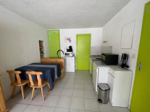 eine Küche mit einem Tisch und Stühlen im Zimmer in der Unterkunft Logement de la ressource in Salins-les-Bains