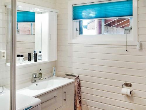 baño con lavabo y ventana con persianas azules en 6 person holiday home in Tengelfjord, en Tengelfjorden