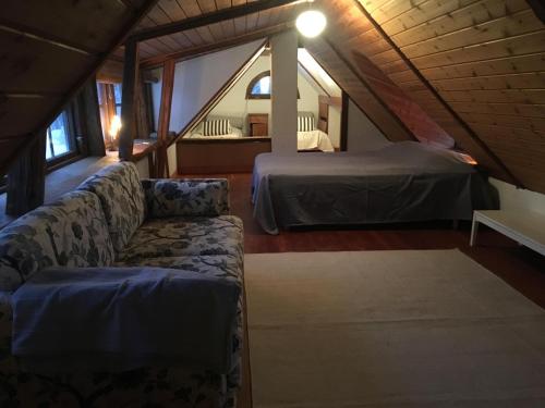 een kamer met een bank en een bed op zolder bij Cottage on unique farm in Höör