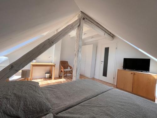 an attic bedroom with a bed and a tv at Apartment Malina - free private parking in Ljubljana