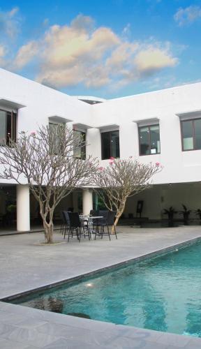 a white house with a swimming pool in front of it at eL Hotel Malang in Malang