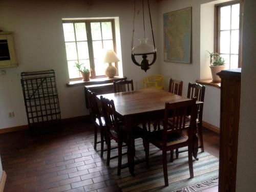 a dining room with a wooden table and chairs at Cottage on unique farm in Höör
