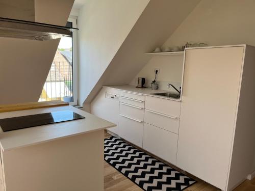 a small kitchen with white cabinets and a window at Apartment Malina - free private parking in Ljubljana