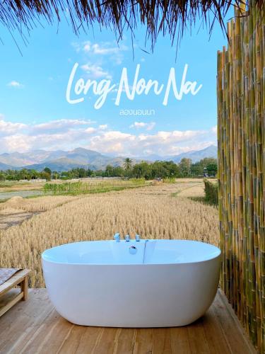 a bath tub in a field with the words long now ne at ลองนอนนา Long Non Na in Ban Lao