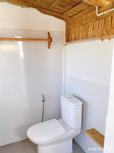 a bathroom with a white toilet in a room at ลองนอนนา Long Non Na in Ban Lao