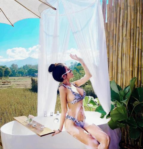 a woman in a bikini sitting in a bath tub at ลองนอนนา Long Non Na in Ban Lao