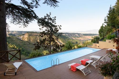 einen Pool mit Stühlen und Bergblick in der Unterkunft Suite Virginia Baglioni in San Michele in Teverina