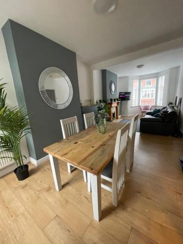 a dining table and chairs in a living room at Bentley Place in Crewe