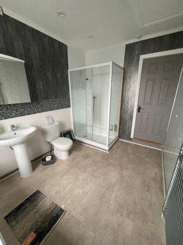 a bathroom with a toilet and a sink and a shower at Bentley Place in Crewe