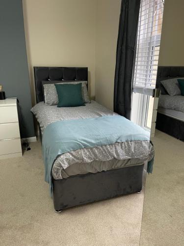 a bedroom with a bed with a black headboard at Bentley Place in Crewe