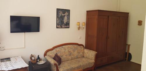 a living room with a chair and a flat screen tv at Kurvilla am Park in Bad Kissingen