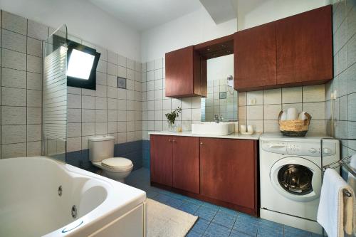 a bathroom with a washing machine and a sink at Villa Politini by PosarelliVillas in Vryses