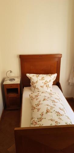 a bed with a wooden headboard and a pillow at Kurvilla am Park in Bad Kissingen