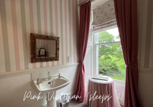 baño con lavabo y ventana en Barton Hall Country House en Pooley Bridge