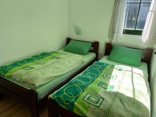 two beds sitting next to each other in a room at Dormire Apartmans in Žabljak
