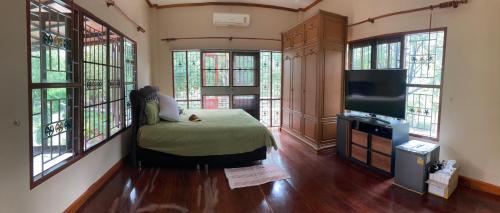 叻丕的住宿－Keith Ratchaburi，客房设有1张床、1台电视和窗户。