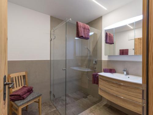 a bathroom with a sink and a glass shower at BERGappartement KINK in Hopfgarten im Brixental