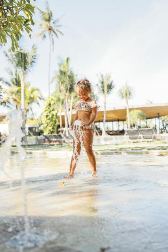 a woman standing in the water on a beach at Segara Village Hotel in Sanur
