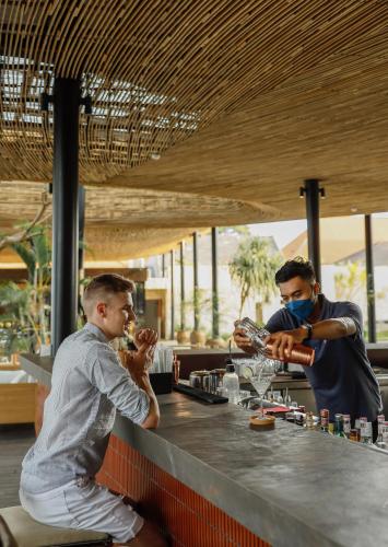 two men sitting at a bar preparing drinks at Segara Village Hotel in Sanur
