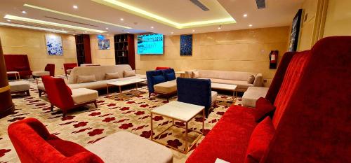a waiting room with couches and chairs and a television at Al Ebaa Hotel in Makkah