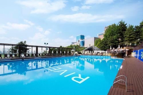 a large swimming pool with blue water in a city at Grand Walkerhill Seoul in Seoul