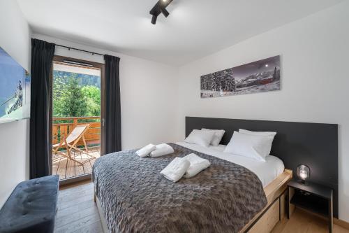 a bedroom with a large bed and a balcony at Quintessence - Apt B303 - BO Immobilier in Châtel