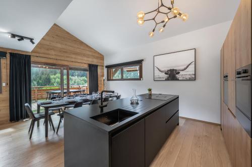 une cuisine avec un évier et une table avec des chaises dans l'établissement Quintessence - Apt B303 - Châtel - Châtel Multipass Été 2025 en option au tarif de 3euros par jour et par personne, à Châtel