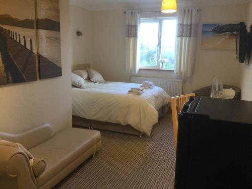 een kleine slaapkamer met een bed en een raam bij Tregenna Licenced Bed & Breakfast in Pembroke