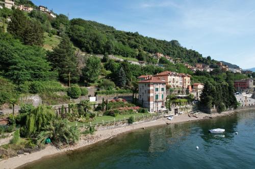 a town on a hill next to a body of water at Villa Marina - Como lake in Bellano