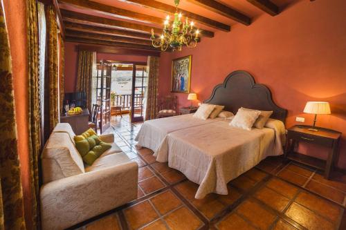 a bedroom with a large bed and a couch at Hotel Emblemático San Marcos in Icod de los Vinos