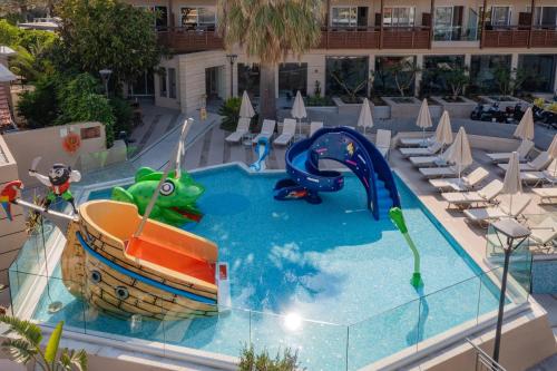 a swimming pool with a boat in the water at Minos Hotel in Rethymno