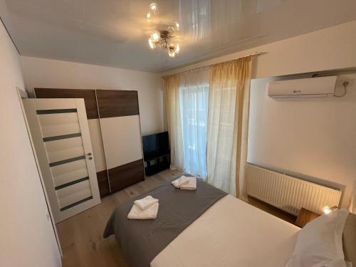 a bedroom with a bed with two towels on it at Mamaia Beach LuxyMar 3 Apartment in Mamaia