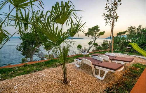 a group of benches sitting next to the water at Holiday Home Villetta Belveder in Baška Voda