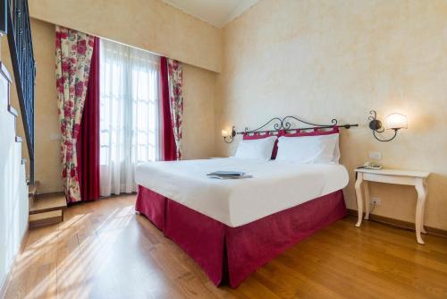 a large white bed in a room with a window at Hotel Borgo Di Cortefreda - Place of Charme in Tavarnelle in Val di Pesa