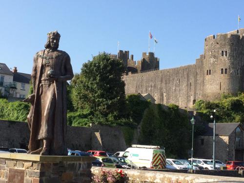 a statue of a man in front of a castle at Tregenna Licenced Bed & Breakfast in Pembroke
