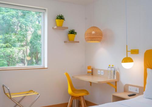 a room with a bed and a table and a window at Bloom Hotel - Brookefield in Bengaluru