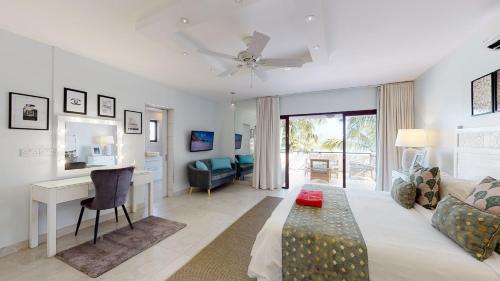 a living room with a couch and a table and a desk at Bel Azur Beachfront Suites and Penthouses by LOV in Trou aux Biches