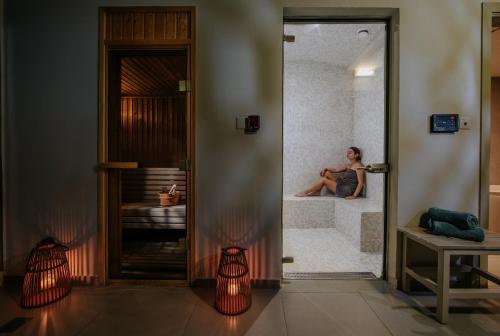 a woman is sitting in a tub in a bathroom at Nissi Beach Resort in Ayia Napa