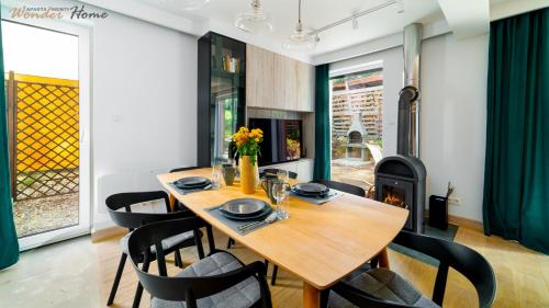 a dining room with a table and chairs and a fireplace at Wonder Home - Domki górskie wolnostojące z prywatnymi tarasami - zielona okolica in Karpacz