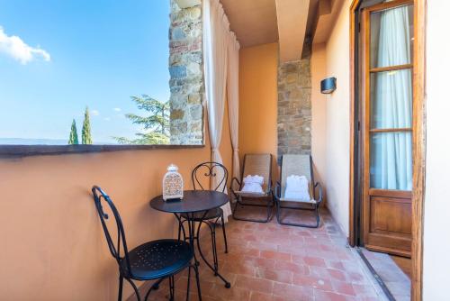 a patio with chairs and a table and a window at Hotel Borgo Di Cortefreda - Place of Charme in Tavarnelle in Val di Pesa